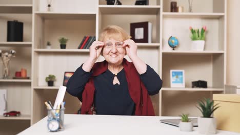 Eine-ältere-Frau-Setzt-Glücklich-Ihre-Brille-Auf-Und-Blickt-In-Die-Kamera
