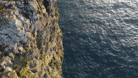 Drone-footage-following-a-very-steep-cliff-with-grass-on-top-on-the-Vagar-island-in-the-Faroe-Islands