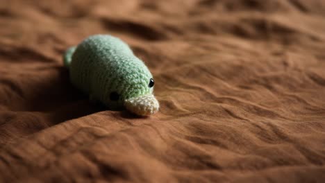 Crochet-Platypus-Stuffed-Animal-lying-on-bed