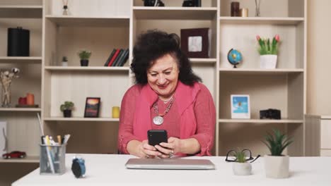 old-woman-plays-a-mobile-game-on-a-smartphone-with-enthusiasm-and-a-smile