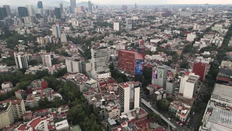 Aerial-view-Insurgentes-Avenue,-in-the-south-of-Mexico-City,-you-can-see-the-Canada-Building-with-monumental-painting