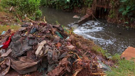 Polluted-river-with-plastic-bags-floating---Polluted-stream-in-Kenya,-East-Africa
