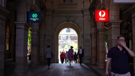 Office-workers-crowd-crossing-GPO-post-office-laneway-between-Queen-and-Elizabeth-street-during-lunch-time-rush-hours-with-Anzac-square-and-central-station-in-the-background-through-the-archway