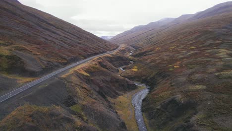 Luftaufnahme:-Folgender-Weißer-Geländewagen-Fährt-Entlang-Der-Isländischen-Ringstraße,-Einer-Malerischen-Autobahn-Durch-Ein-Malerisches,-Abgelegenes-Fjordgebiet,-Das-In-Der-Ferne-Zu-Nebel-Und-Dunst-Führt