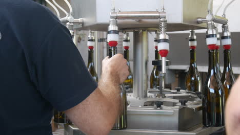 Workers-using-a-machine-to-bottle-some-wine