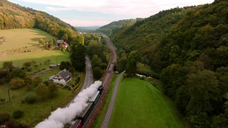 Aerial-view-of-a-steam-train-passing-through-an-autumn-landscape