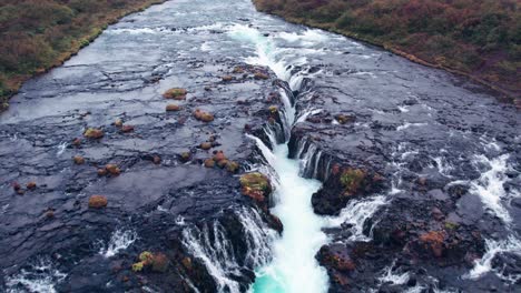 Luftaufnahme:-Überführung-Des-Bruarfoss-Wasserfalls-Am-Golden-Circle-Im-Süden-Islands,-Der-Mit-Der-Wunderschönen-Blauen-Kaskade-Von-Wasserfällen,-Die-In-Das-Darunter-Liegende-Tauchbecken-Münden,-Sehr-Malerisch-Ist