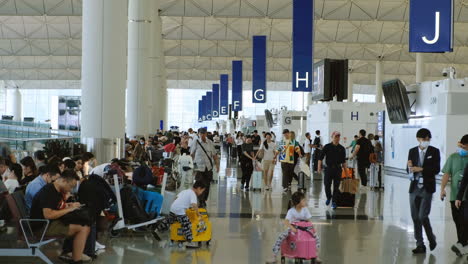 Zeitlupe-Von-Passagieren,-Die-Durch-Die-Flughafenhalle-Des-Internationalen-Flughafens-Hongkong-Laufen