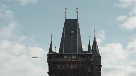 Helicópteros-Vuelan-Por-La-Torre-Del-Puente-De-La-Ciudad-Vieja,-Praga-Bajo-Un-Cielo-Nublado
