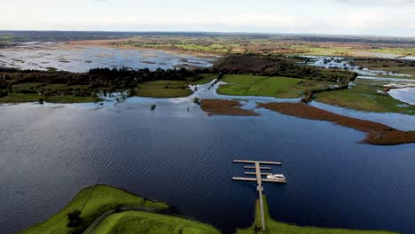 A-4K-dropping-drone-reveal-of-the-rath-at-Clonmacnoise-on-the-River-Shannon-in-flood-Co-Offaly-Ireland