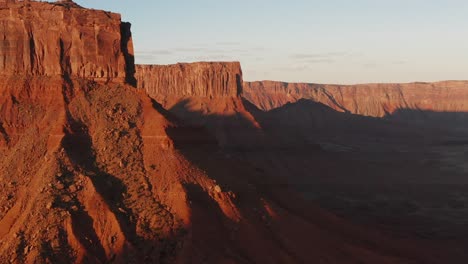Klippen-Und-Sandsteinfelsen-In-Moab,-Utah-Während-Der-Goldenen-Stunde,-Drohnen-Parallaxenrückzug-Zeigt-Schichten-Auf,-Die-Aufgenommen-Wurden