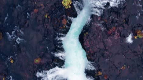 Luftaufnahme:-Von-Oben-Nach-Unten,-Nahansicht-Des-Bruarfoss-Wasserfalls-Im-Süden-Islands,-Der-Mit-Der-Wunderschönen-Blauen-Kaskade-Von-Wasserfällen,-Die-In-Das-Darunter-Liegende-Tauchbecken-Münden,-Sehr-Malerisch-Ist