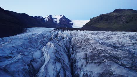 Aerial:-Reverse-flyover-of-glaciers-serpentine-path-with-deep-crevasses-and-jagged-ice-formations,-evidence-of-climate-change-impact-on-the-constant-movement-and-transformation-of-this-natural-wonder