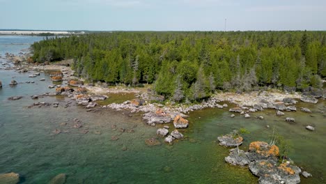 Aerial-ascent-backup-of-wilderness-forested-coastline,-les-cheneaux-islands,-michigan