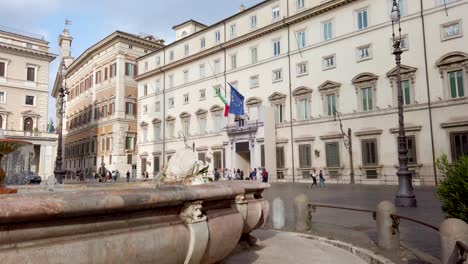Chigi-Palace-in-Rome-in-the-background,-seat-of-the-Council-of-Ministers-and-the-official-residence-of-the-Prime-Minister-in-the-square-Piazza-Colonna