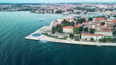 Antena-Sobre-La-Costa-Del-Mar-Del-Monumento-Al-Atardecer-De-Zadar,-También-Conocido-Como-El-Monumento-Al-Sol,-Una-Instalación-De-Arte-Ubicada-En-La-Hermosa-Ciudad-Croata-De-Zadar