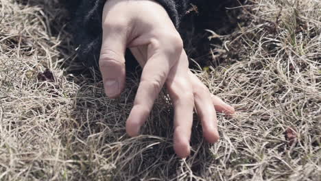 Close-up-of-a-woman's-hand-sensually-touching-grass