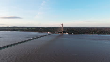 A-cinematic-vista:-Humber-Bridge-shines-in-the-sunset's-warmth,-with-a-procession-of-cars-forming-a-mesmerizing-spectacle