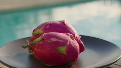 Dragon-fruit-on-a-plate-with-swimming-pool-in-the-background-at-sunset-in-golden-hour