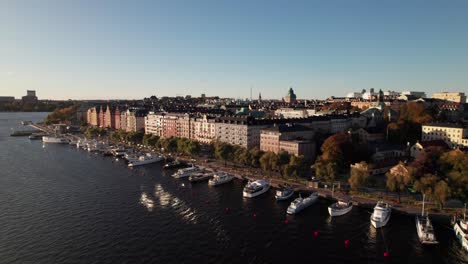Classic-colorful-waterfront-buildings-and-ships-in-Stockholm,-Sweden,-aerial-4K