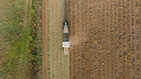 Aerial:-Top-down-follow-shot-of-tractor-plowing-the-soil