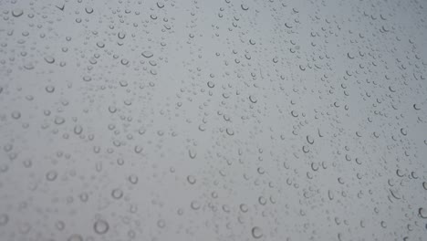 Nahaufnahme-Eines-Regnerischen-Glases,-Während-Regentropfen-Bei-Trübem-Und-Bewölktem-Wetter-Auf-Ein-Fenster-Treffen