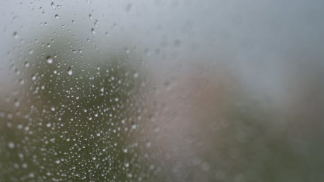 Enge-Fokusansicht-Von-Regnerischem-Glas,-Während-Bei-Düsterem-Und-Bewölktem-Wetter-Regentropfen-Auf-Einem-Fenster-Zu-Sehen-Sind