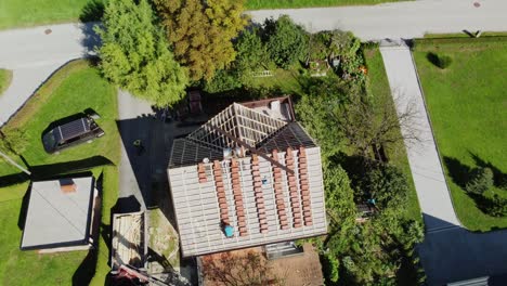Drone-push-in-tilt-down-above-neat-columns-of-red-roofing-tiles-on-house