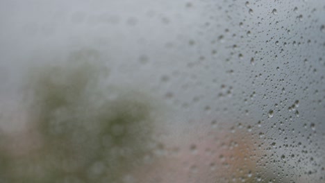 Eine-Nahaufnahme-Und-Enge-Fokusansicht-Von-Regnerischem-Glas,-Während-Regentropfen-Auf-Einem-Fenster-Zu-Sehen-Sind