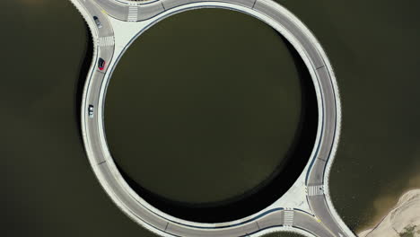 Cars-Crossing-Circular-Bridge-Over-Laguna-Garzon-Uruguay,-Bird's-eye-Drone-Rotate