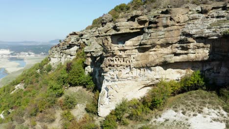 Aerial-view-of-rock-sanctuary,-Chit-Kaya,-an-ancient-cliff-in-Bulgaria,-with-an-expansive-view-of-the-mountain
