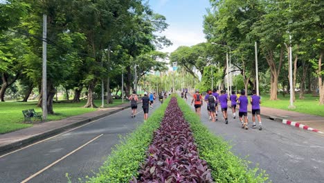 Joggers-jog-in-the-multi-functional-Lumpini-Park-in-Bangkok,-Thailand