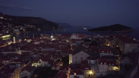 Casco-Antiguo-De-Dubrovnik-De-Noche:-Calles-Luminosas,-Mar-Y-Una-Isla-Lejana