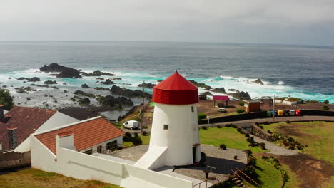 Aerial-Drone-show-of-small-white-and-red-lighthouse-located-at-the-coastline-in-Sao-Miguel-Island-in-the-Azores---Portugal