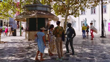 Besucher-Und-Touristen-Huldigen-Der-Bronzestatue-O-Cauteleiro-In-Lissabon