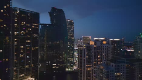 Flying-towards-illuminated-skyscrapers-at-night,-downtown-Miami