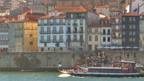 Boat-with-truurists-sailing-on-the-Douro-River-in-the-Ribeira-region-of-Porto,-Portugal