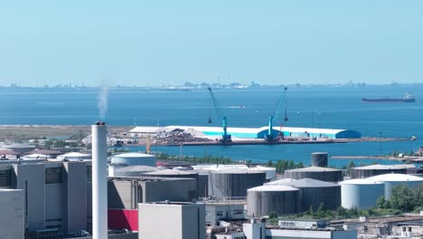 Modern-industrial-area-on-the-port-of-Malmo,-Sweden,-telephoto-aerial-chimney
