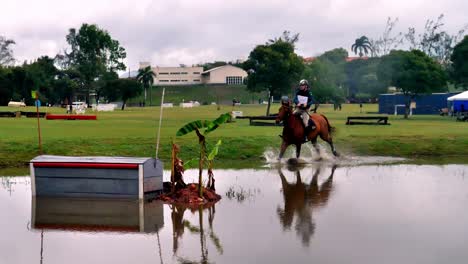 A-horse-and-rider-jump-over-an-obstacle-in-the-water-during-a-cross-country-race
