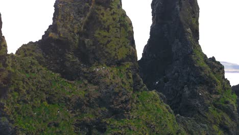 Aerial-closeup-view-of-Reynisdrangar,-basalt-sea-stacks-located-near-village-of-Vík-in-Iceland