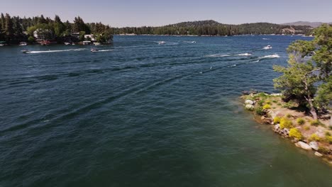 boats-and-yachts-passing-through-the-scene-on-Lake-Arrowhead-California-summer-sunny-day-AERIAL-DOLLY
