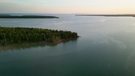 Aerial-daytime-fly-to-forested-peninsula,-Lake-Huron,-Michigan
