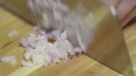 Chopping-shallots-with-a-knife-on-a-cutting-board