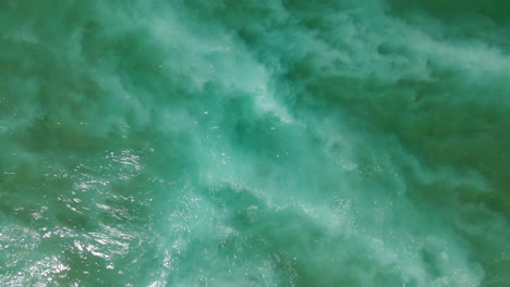Aerial-overhead-view-of-waves-and-foam-of-the-Portuguese-Atlantic-breaking-on-the-shore