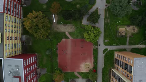 Aerial-top-drone-shot-of-empty-kids-playground-in-the-middle-of-city-during-cloudy-day
