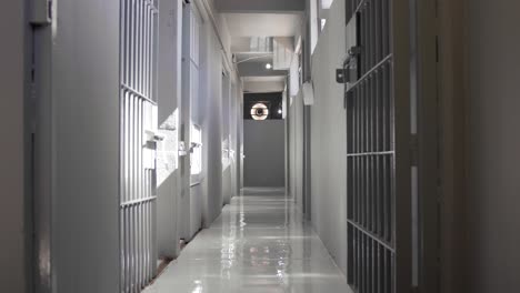 Gray-hallway-full-of-empty-prison-jail-cells-during-the-day