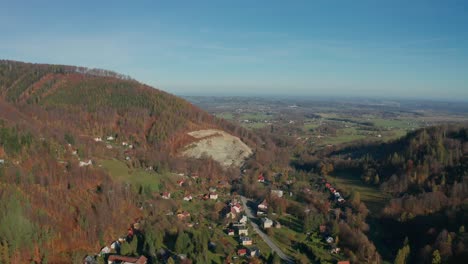 Aerial-drone-shot-of-village-and-quarry-in-the-middle-of-Beskydy-mountains-during-sunny-autumn-fall-day