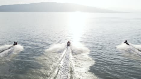 Jet-Ski-Fahrer-Rennen-Bei-Sonnenuntergang-Mit-Ihren-Waverunnern-Auf-Dem-Utah-Lake,-Drohnenansicht-Aus-Der-Luft