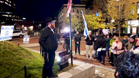 A-rabbi-speaks-to-a-group-of-people-supporting-Israel-in-their-war-against-Hamas-in-the-Middle-East