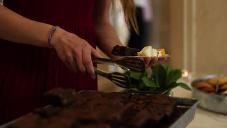 Person-with-Tongs-Serving-Brownies-and-Other-Hors-d'Oreuvre-at-Catered-Wedding-Reception-Party